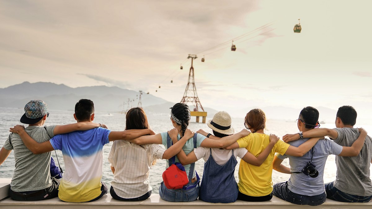 Diverse group of people smiling and conversing outdoors